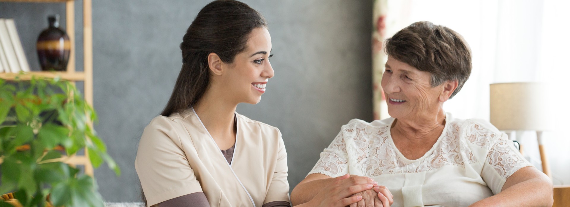 Young nurse comforting elderly woman in home health care Gracia Hospice