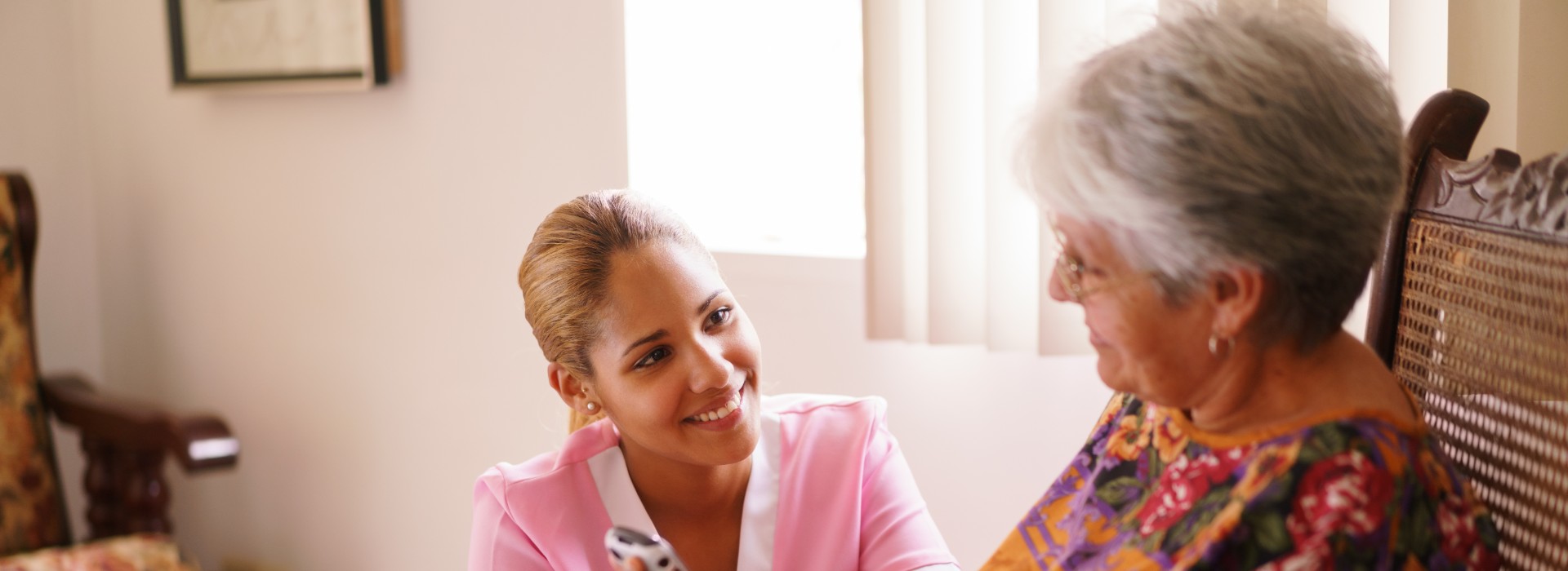 young nurse comforting elderly woman in home health care Gracia Hospice