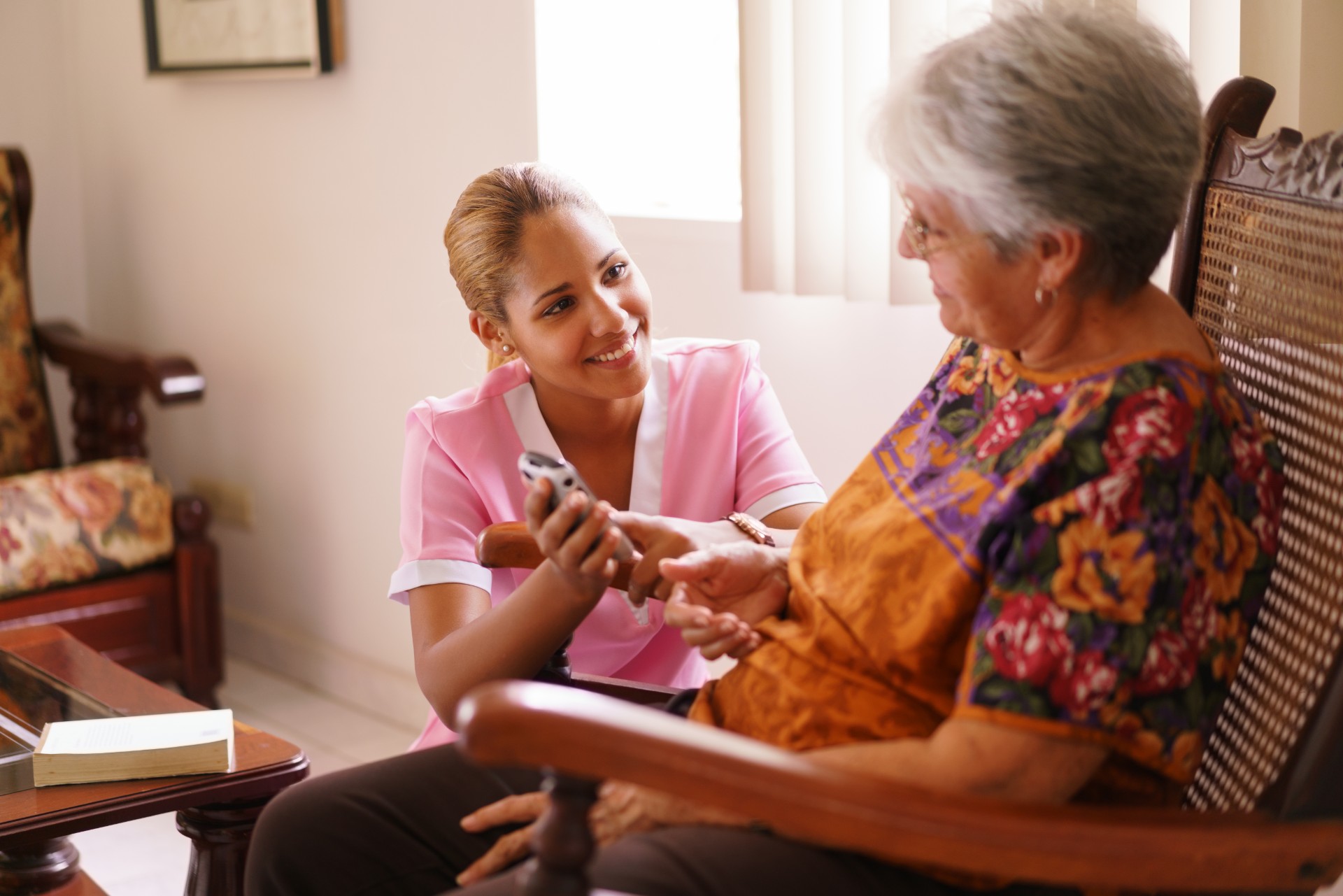 Young nurse comforting elderly woman in home health care Gracia Hospice